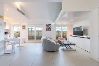 a living room with a couch and a table at LB Vacation Rentals I Elegant Apartment with Terrace & Mezzanine in the heart of Cannes in Cannes
