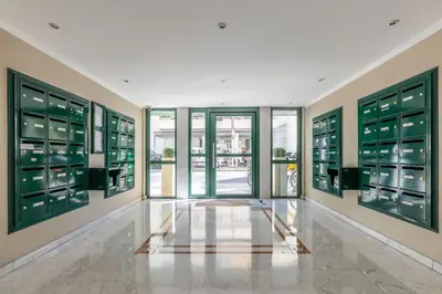 a hallway with green windows and a lobby with a tile floor at LB Vacation Rentals I Elegant Apartment with Terrace & Mezzanine in the heart of Cannes in Cannes
