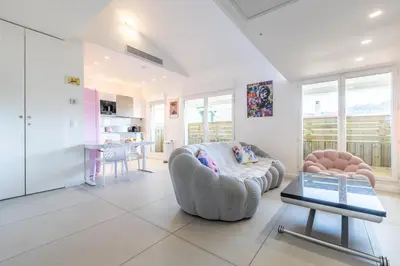 a living room with a couch and a table at LB Vacation Rentals I Elegant Apartment with Terrace & Mezzanine in the heart of Cannes in Cannes