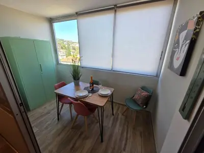 a small table and chairs in a room with windows at Apartment Les Sablons-3 by Interhome in Cannes