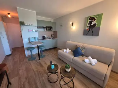 a living room with a couch and a kitchen at Apartment Les Sablons-3 by Interhome in Cannes