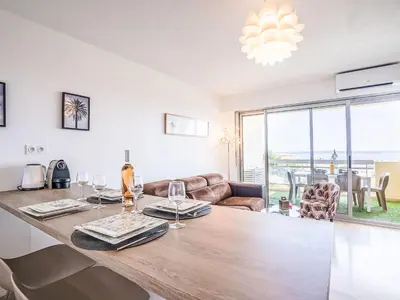 a dining room and living room with a large wooden table at Apartment Cannes Parc-2 by Interhome in Cannes