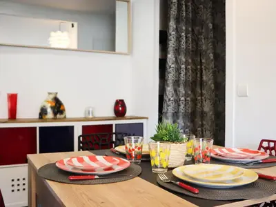 a dining room table with plates and glasses on it at Apartment les Gemeaux by Interhome in Le Cannet