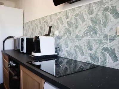 a kitchen with a counter top with a toaster and a coffee maker at Apartment les Gemeaux by Interhome in Le Cannet