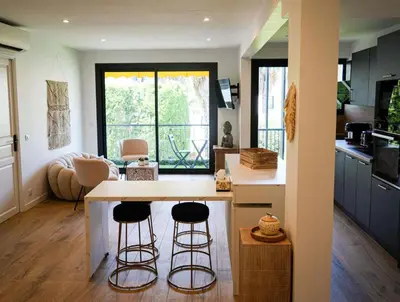 a kitchen with two bar stools and a counter at Bali à Cannes in Cannes