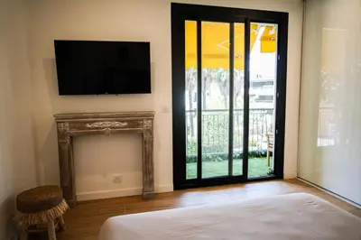 a room with a television and a fireplace with a bed at Bali à Cannes in Cannes