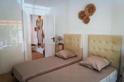a bedroom with two beds and a mirror on the wall at Bali à Cannes in Cannes