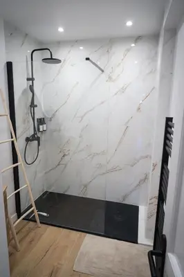 a bathroom with a shower with a marble wall at Bali à Cannes in Cannes