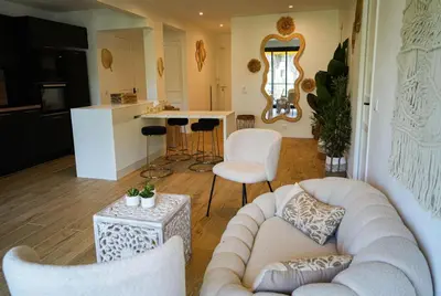 a living room with a couch and chairs and a kitchen at Bali à Cannes in Cannes