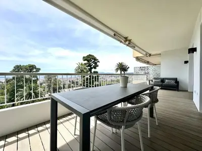 a black table and chairs on a balcony with a view at appartement cannes in Cannes