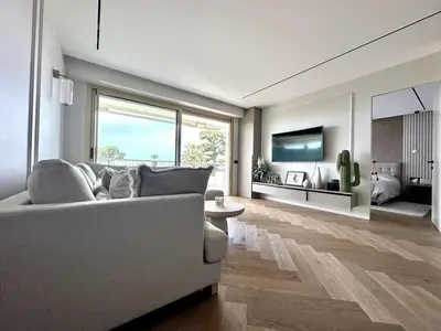 a living room with a couch and a large window at appartement cannes in Cannes