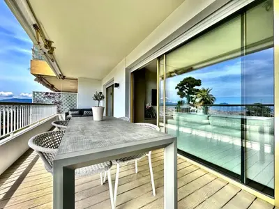 a dining table on a balcony with a view of the ocean at appartement cannes in Cannes