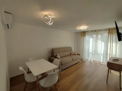 a living room with a couch and a table and chairs at Cannes Fleurs de Provence - proche centre-ville in Cannes