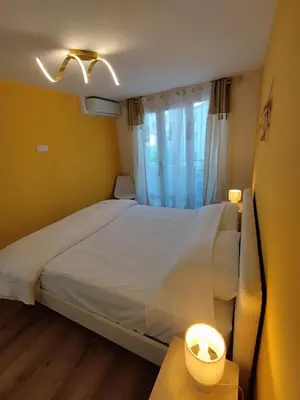 a bedroom with a white bed and a window at Cannes Fleurs de Provence - proche centre-ville in Cannes