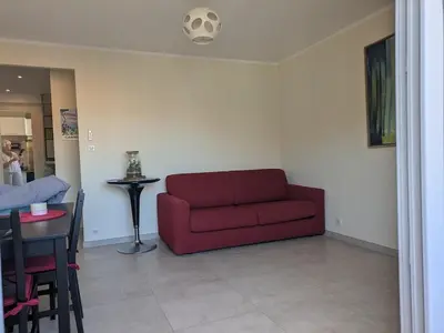 a living room with a red couch and a table at Charming 2-room apartment in Cannes in Cannes