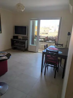 a living room with a table and chairs and a television at Charming 2-room apartment in Cannes in Cannes