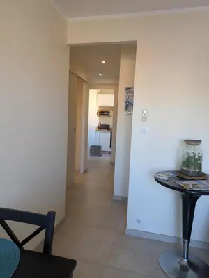 a living room with a table and a hallway at Charming 2-room apartment in Cannes in Cannes