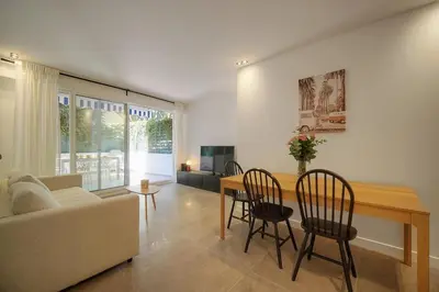 a living room with a couch and a table and chairs at Modern 3BR with Patio, Walk to Beach and Croisette in Cannes