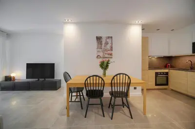 a kitchen with a table and chairs and a television at Modern 3BR with Patio, Walk to Beach and Croisette in Cannes
