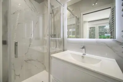 a white bathroom with a sink and a shower at Modern 3BR with Patio, Walk to Beach and Croisette in Cannes