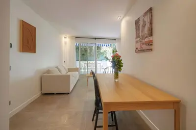 a dining room with a table and a couch at Modern 3BR with Patio, Walk to Beach and Croisette in Cannes