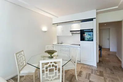 a kitchen with a glass table and white cabinets at REF 1233 - Cannes Croisette - Apartment for rent in Cannes