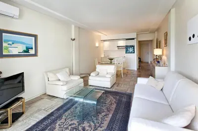a living room with white furniture and a tv at REF 1233 - Cannes Croisette - Apartment for rent in Cannes