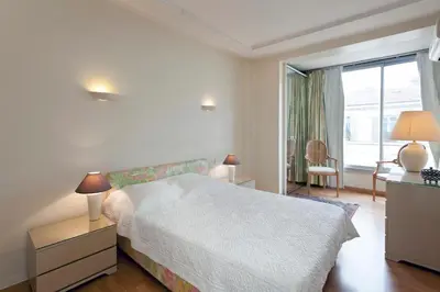 a white bedroom with a bed and a window at REF 1233 - Cannes Croisette - Apartment for rent in Cannes