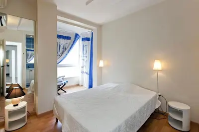 a bedroom with a white bed and a large window at REF 1233 - Cannes Croisette - Apartment for rent in Cannes