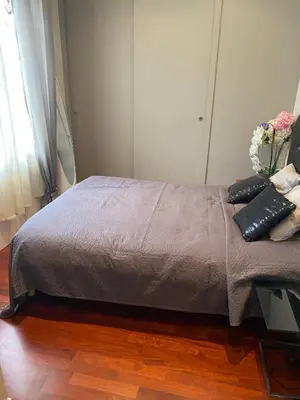 a bed in a bedroom with a vase of flowers at REF 843 - Cannes Croisette - Sea view apartment for rent in Cannes