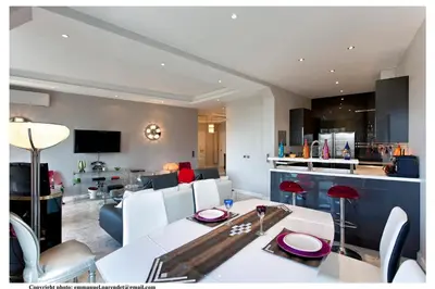 a dining room and living room with a white table and chairs at REF 843 - Cannes Croisette - Sea view apartment for rent in Cannes