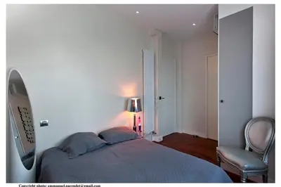 a bedroom with a bed and a chair and a lamp at REF 843 - Cannes Croisette - Sea view apartment for rent in Cannes