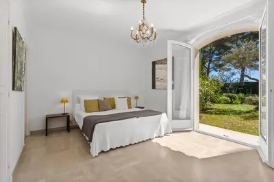 a white bedroom with a bed and a large window at REF 1223 - Cannes - Villa for rent in Vallauris