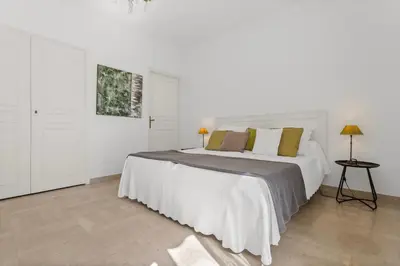 a white bedroom with a large white bed with pillows at REF 1223 - Cannes - Villa for rent in Vallauris