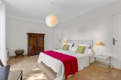 a white bedroom with a large bed with a red blanket at REF 1223 - Cannes - Villa for rent in Vallauris