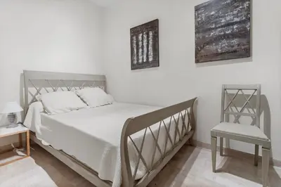 a bedroom with a white bed and a chair at REF 1223 - Cannes - Villa for rent in Vallauris