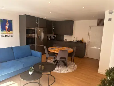 a living room with a blue couch and a table at T2 refait à neuf à 50m de la plage Moure Rouge in Cannes