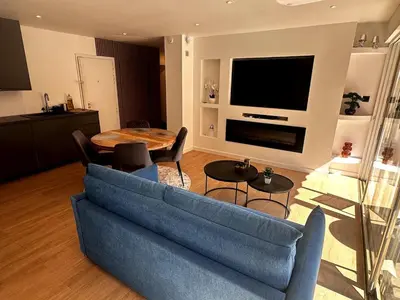 a kitchen and living room with a table and chairs at T2 refait à neuf à 50m de la plage Moure Rouge in Cannes