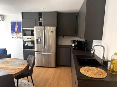 a kitchen with a table and chairs in a room at T2 refait à neuf à 50m de la plage Moure Rouge in Cannes