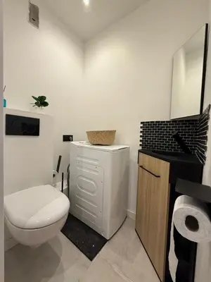 a white bathroom with a toilet and a sink at T2 refait à neuf à 50m de la plage Moure Rouge in Cannes
