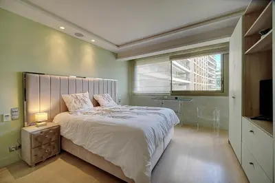 a bedroom with a large bed and a window at REF 1434 - Cannes Croisette - Sea view apartment for rent in Cannes