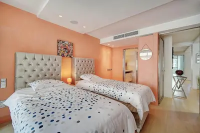 two beds in a bedroom with orange walls at REF 1434 - Cannes Croisette - Sea view apartment for rent in Cannes