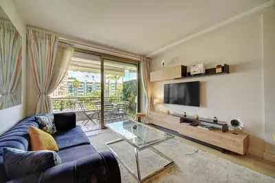 a living room with a blue couch and a tv at REF 1434 - Cannes Croisette - Sea view apartment for rent in Cannes