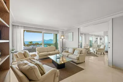a living room with couches and a living room with a view at REF 1991 - Cannes Croisette - Sea view apartment for rent in Cannes