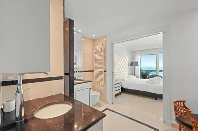 a bathroom with a sink and a bedroom with a bed at REF 1991 - Cannes Croisette - Sea view apartment for rent in Cannes