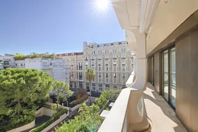 an apartment balcony with a view of a building at REF 1991 - Cannes Croisette - Sea view apartment for rent in Cannes