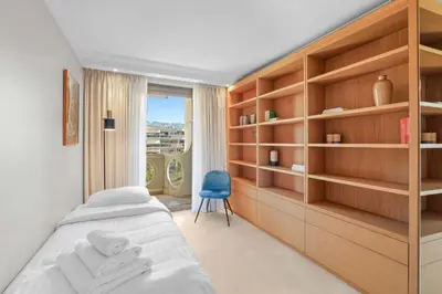 a bedroom with a bed and a blue chair at REF 1991 - Cannes Croisette - Sea view apartment for rent in Cannes