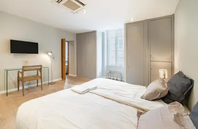 a bedroom with a large white bed and a desk at Appartement Cannes, Majestic in Cannes