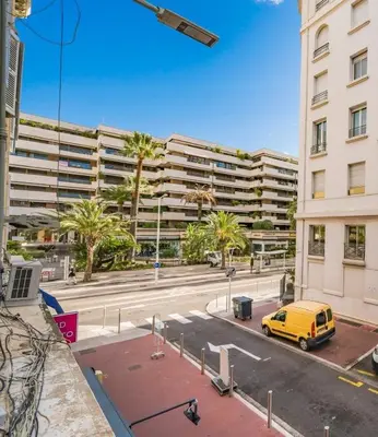 a yellow van parked in front of a large building at Appartement Cannes, Majestic in Cannes