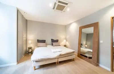 a bedroom with a large bed and a mirror at Appartement Cannes, Majestic in Cannes